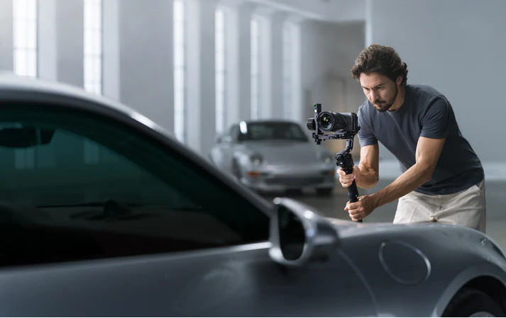 Camera operator filming with a DJI RS 5 camera gimbal in a showroom