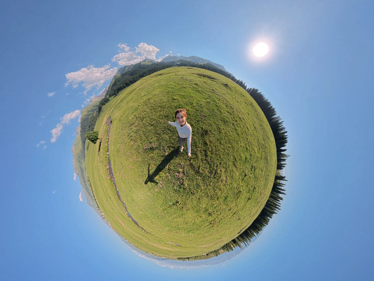 DJI Osmo 360 II tiny-planet sample with a person standing in a green meadow
