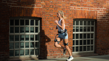 Person wearing Hypershell X Go outdoors beside a brick building