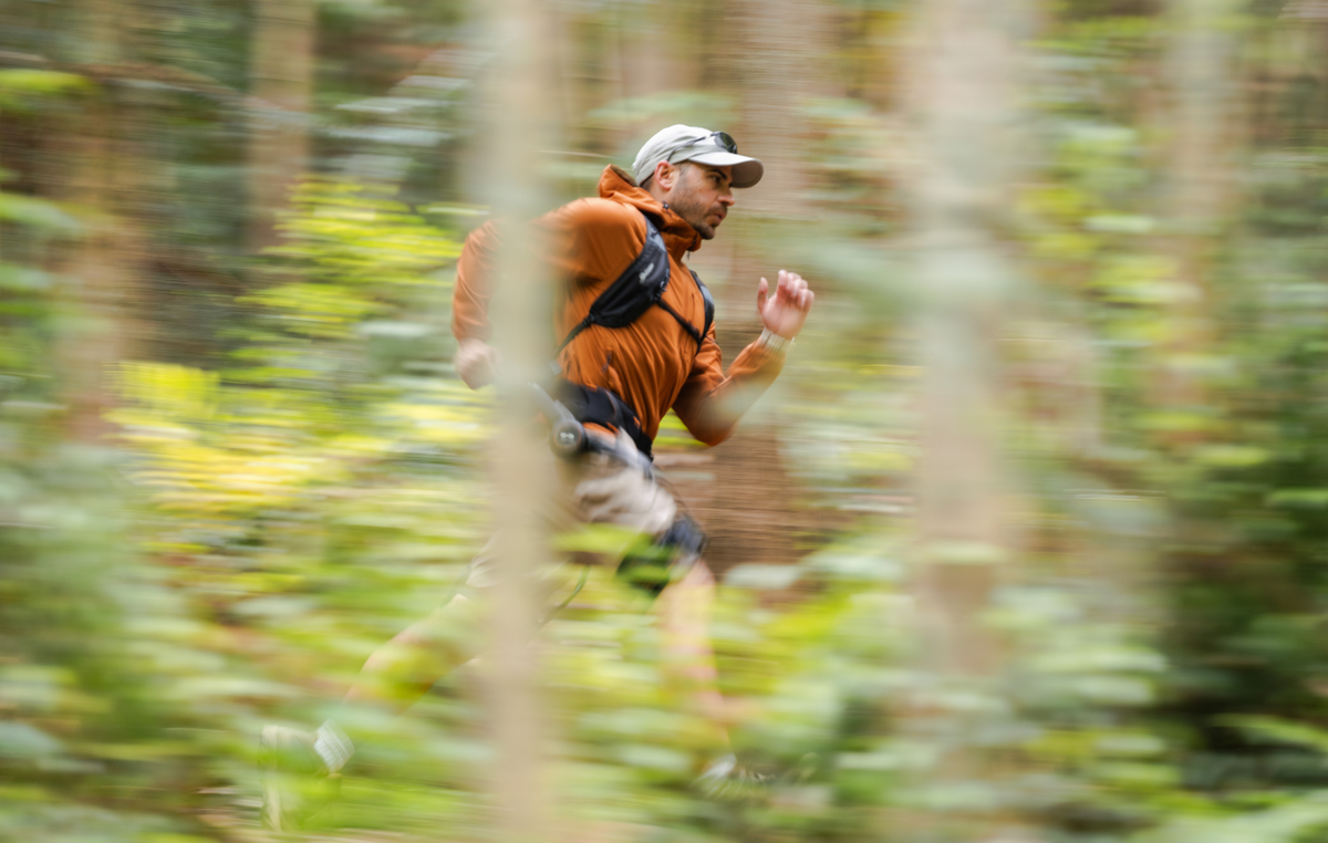 Runner wearing a Hypershell X Series S exoskeleton on a wooded path