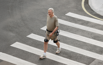 Person wearing a Hypershell X Series S exoskeleton while crossing a city street