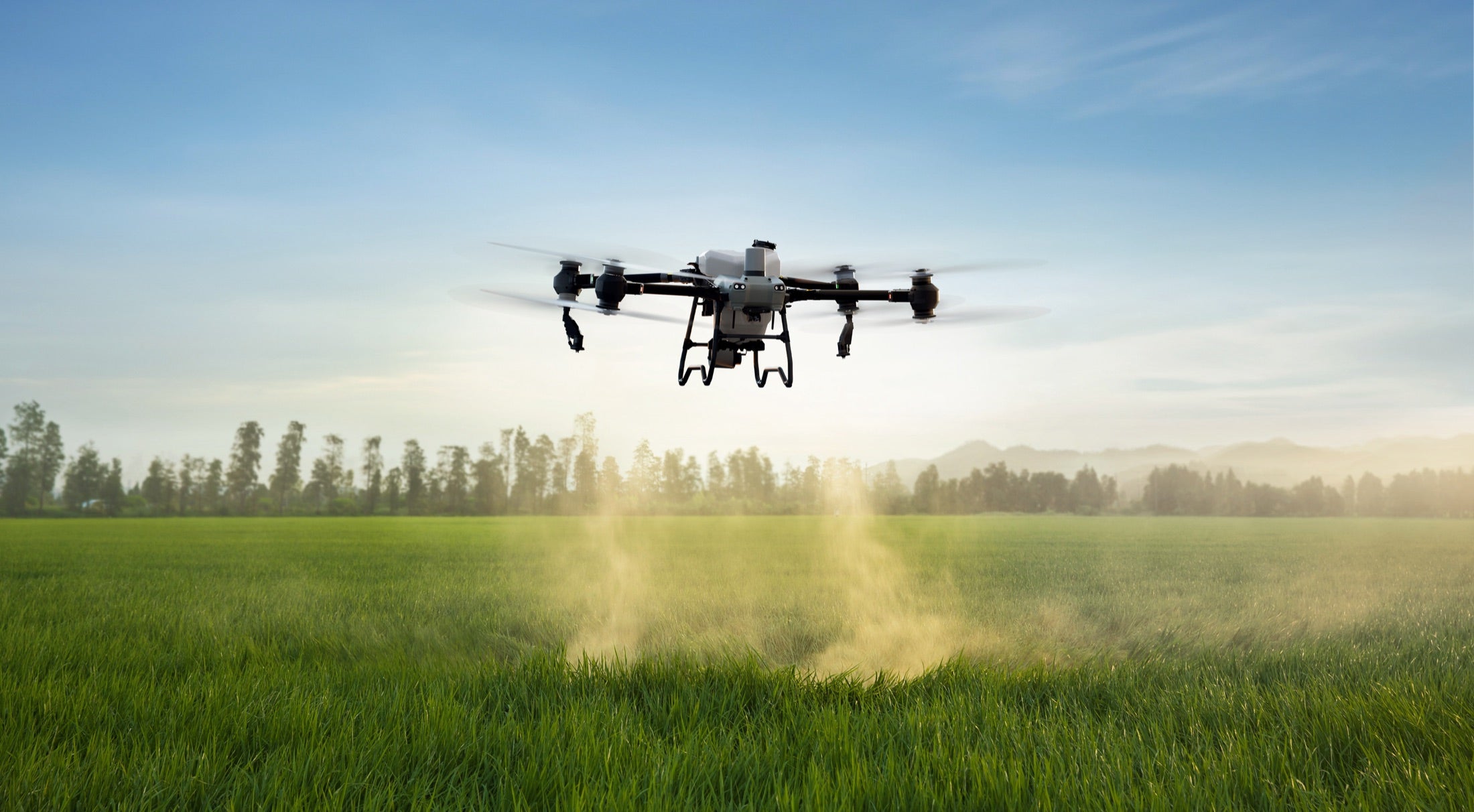 DJI AGRAS agriculture drone operating over a farm field
